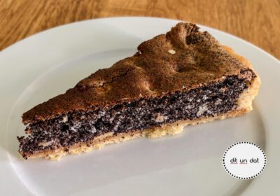 Ein Stück Kuchen auf einem weißen Teller. Die Füllung ist mit schwarzem Mohn, der Rand braun.