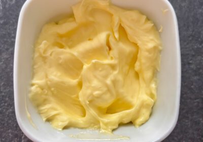 Ein weißes, quadratisches Porzellan-Schälchen mit Butter gefüllt.