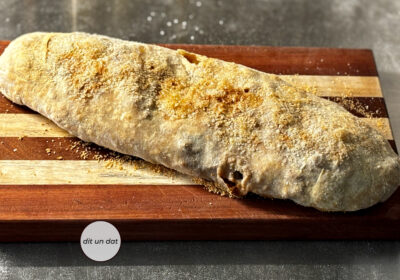 Fertig gebackener Apfelstrudel auf einem Holzbrett.